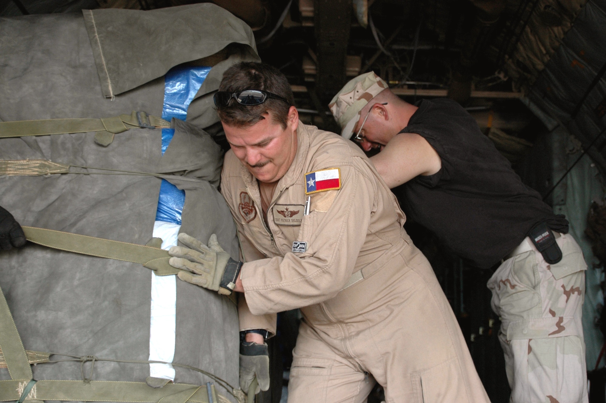 Staff Sgt. Patrick Delselva uses some muscle to position a pallet filled with tarps, tents and mosquito netting on a C-130 Dec. 9. The Air Force is air-dropping supplies to flood refugees in eastern Kenya. Sergeant Delselva is a loadmaster from Dyess Air Force Base, Texas, deployed to the 746th Expeditionary Airlift Squadron. After weeks of rain in Dadaab region in Kenya, camps housing about 160,000 Somali refugees who fled their country 14 years ago following an uprising were damaged and many crops were destoyed. The Combined Joint Task Force - Horn of Africa military officials monitoring the developments began Operation Unity Knight and sent an Air Force C-130 assigned to the 379th Air Expeditionary Wing based in Southwest Asia because the roads in the area were impassable. (U.S. Air Force photo/Tech. Sgt. Stephen Staedler)
