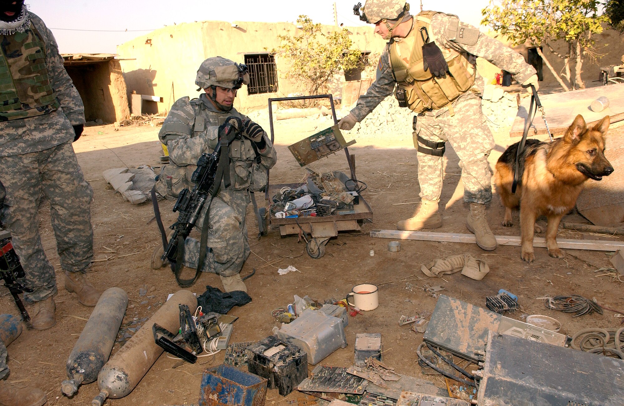 Army Pfc. Samuel Medrano and Air Force Staff Sgt. Russell McLaughlin load up materials for making improvised explosive devices found Dec. 8 in the village of Tall Qabb, Kirkuk Province. Private Medrano is from Alpha Company, 2nd Battalion, 35th Infantry Regiment, 25th Infantry Division, and Sergeant McLauglin is a K-9 dog handler attached to the 25th Infantry Division. (U.S. Air Force photo/Staff Sgt. Samuel Bendet)
