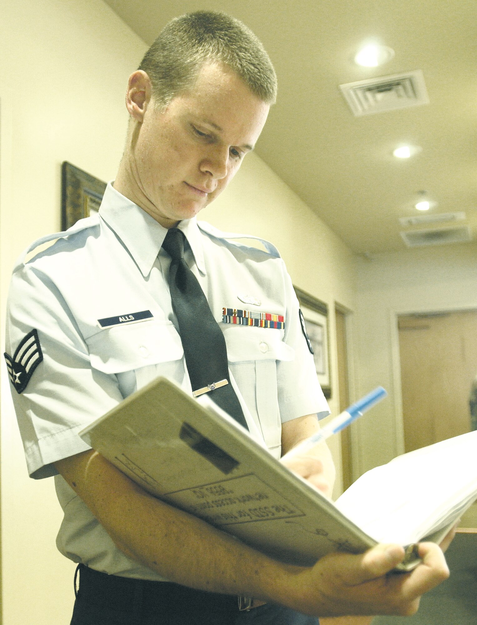 Senior Airman Christopher Alls, 99th Services Squadron Nellis Inn front desk clerk, updates the maintenance log. Airman Alls saved the life of a guest by using the Heimlich maneuver. (U.S. Air Force photo/Senior Airman Larry Reid Jr.)