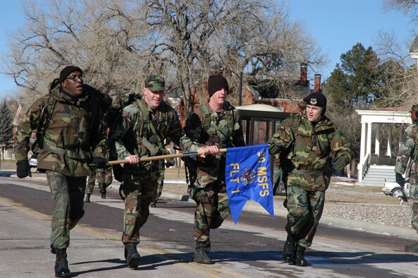 A team from the 90th Missile Security Forces Squadron sprints to the finish line during the six-mile ruck march held here Dec. 1. Two hundred Airmen participated in the march that honored veterans of the Korean War's Chosin Reservoir Campaign.