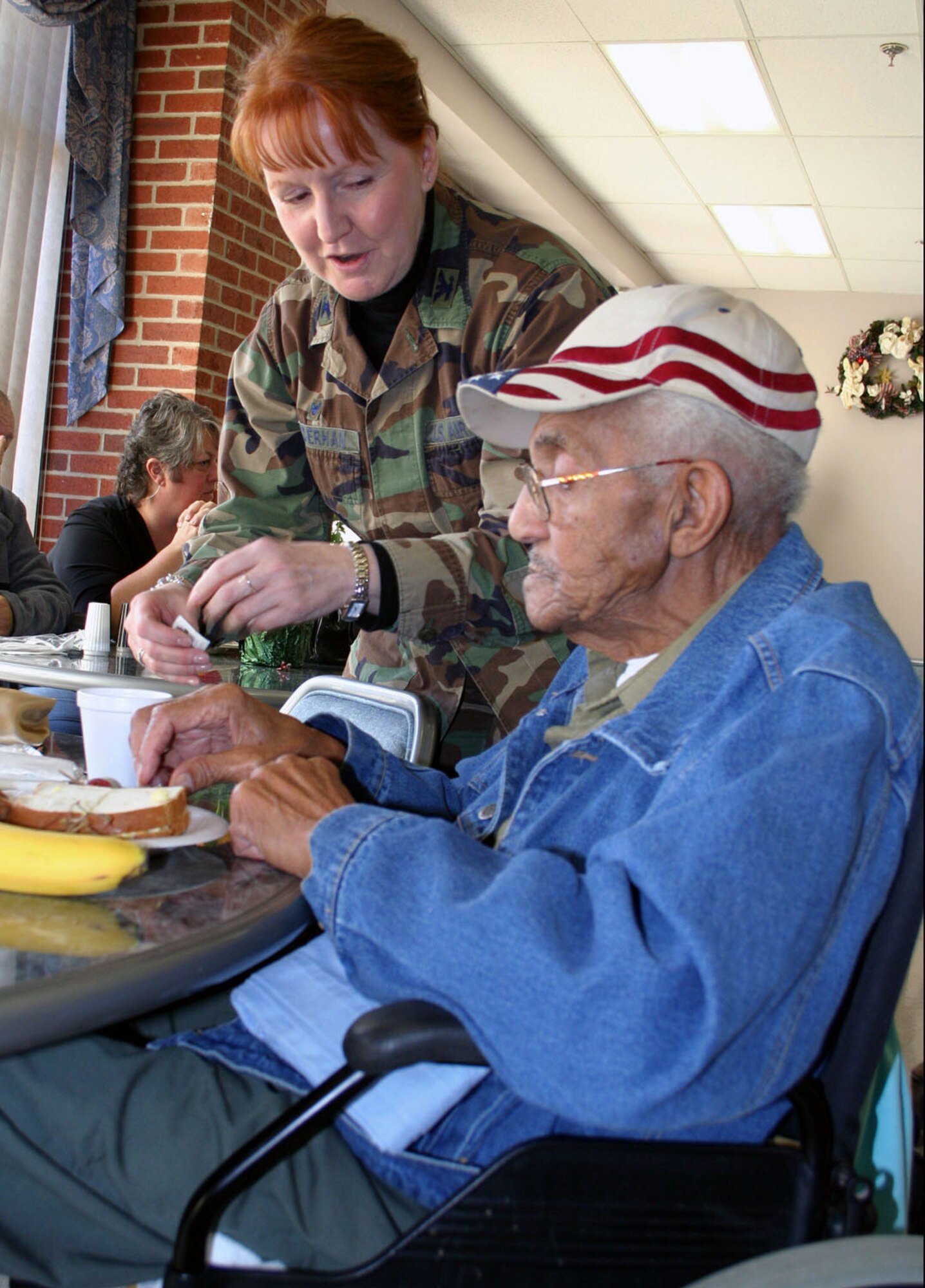DAYTON, Ohio – Col. Mary Henderhan, 445th Mission Support Group commander helps veteran Howard Roberts with his plate of food during her visit at the Dayton Veteran’s Hospital during their holiday party. (U.S. Air Force photo/Maj. Jose Cardenas).