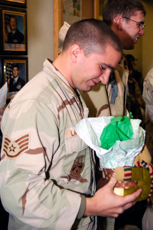 HANSCOM AIR FORCE BASE, MASS. -- Staff Sgt. Kyle LaTulippe, 66th Security Forces Squadron, examines the gift he was presented by 66 SFS Commander Maj. Tamara Mayer upon his return. All of the returning deployers received gifts. (U.S. Air Force Photo by Jan Abate)
