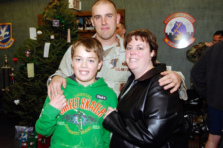 Hanscom AFB -- Tech. Sgt. Beau Rogerson, 66th Security Forces Squadron, poses with his wife, Samantha, and son, Sean upon his return home from a deployment in suppor t of the Global War on Terror.  (U.S. Air Force Photo by Jan Abate)