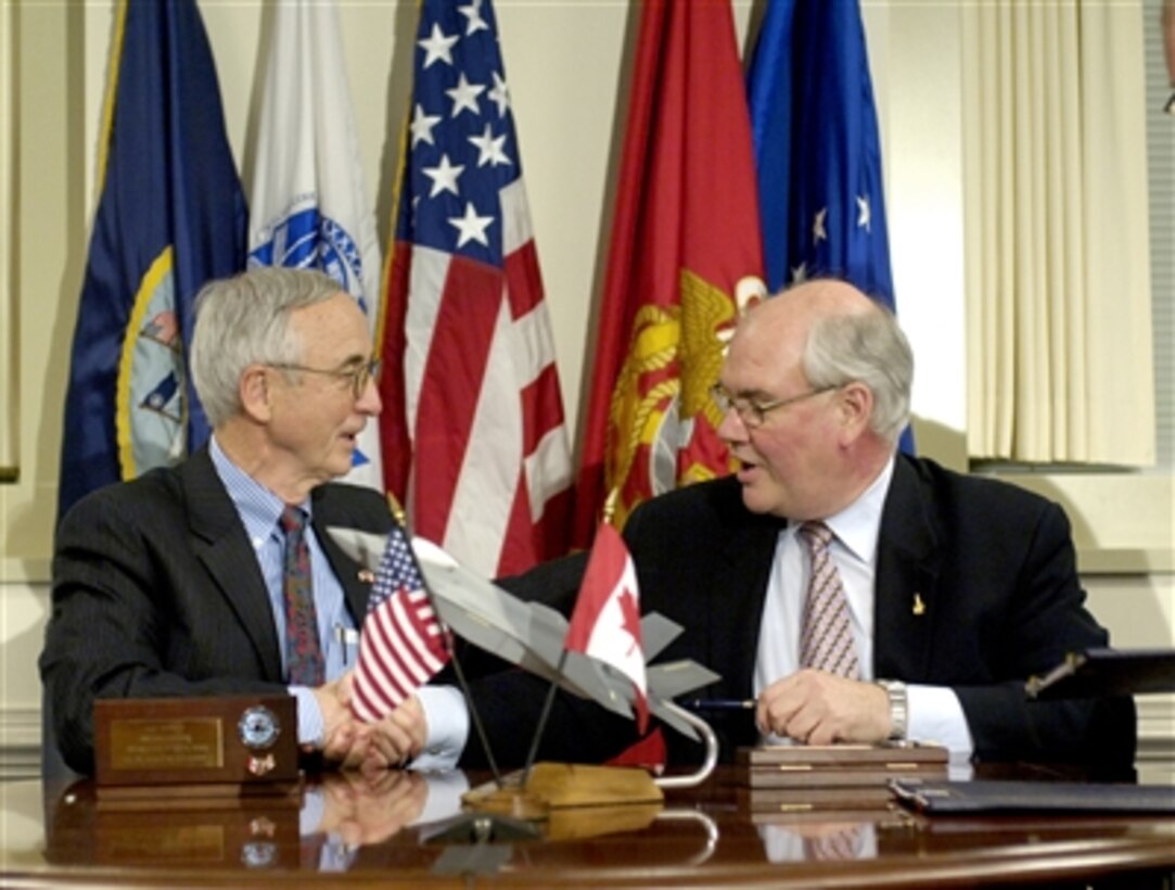 Deputy Secretary of Defense Gordon England (left) and Canadian Deputy Minister of Defence Ward P. D. Elcock (right) shake hands after signing a memorandum of understanding concerning the future of the Joint Strike Fighter program at the Pentagon on Dec. 11, 2006.  The document establishes a framework for the production, sustainment, and follow-on development of the aircraft.  