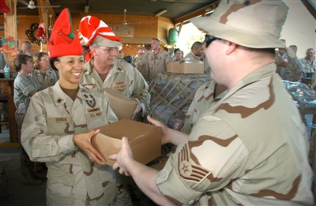 Petty Officer 1st Class Malika Derios, Southwest Asia 1st Class Petty Officer's Association's president,  hands gifts to servicemembers from Camp Lemonier and Combined Joint Task Force - Horn of Africa, Dec. 10.