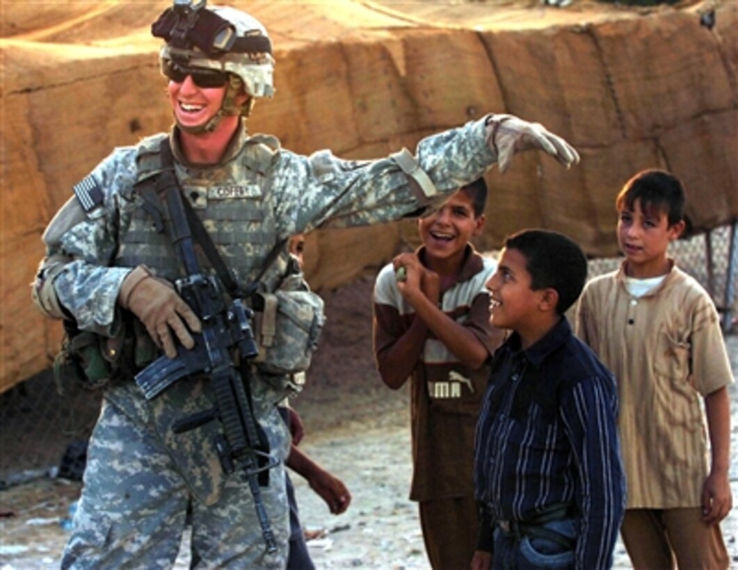 U.S. Army Spc. Russell Coffey, from 3rd Battalion, 320th Field Artillery Regiment, 3rd Brigade Combat Team, 101st Airborne Division (Air Assault), interacts with children during a patrol in a small village on the outskirts of Tikrit, Iraq, Dec. 12, 2006. 