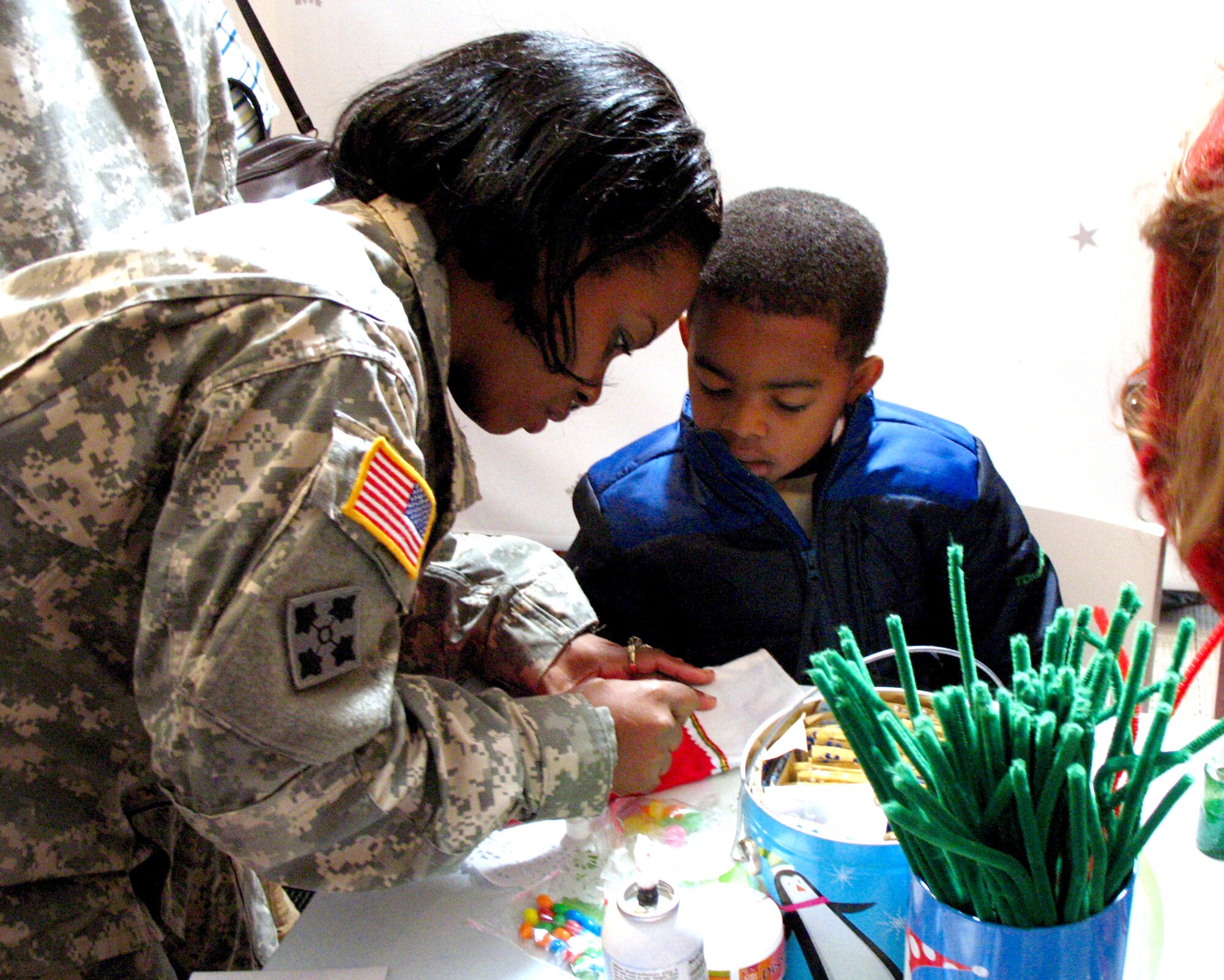 Army Sgt. Janet Rush helps her son Cameron Nails make a Christmas stocking during Operation Christmas Dec. 13 at the Texas National Guard Armory in San Antonio. Operation Christmas is an outreach program designed to show support to military families during the holiday season. (U.S. Air Force photo/Airman 1st Class Lana Mills) 
