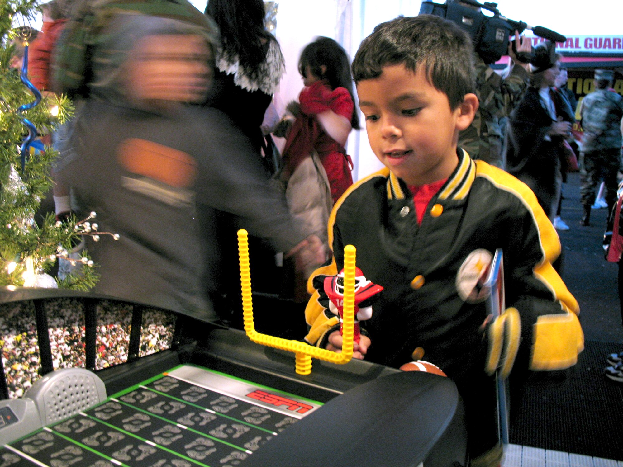Michael Lowery plays with a football game during Operation Christmas Dec. 13 at the Texas National Guard Armory in San Antonio. Operation Christmas is an outreach program designed to show support to military families during the holiday season. (U.S. Air Force photo/Airman 1st Class Robbie Arp) 
