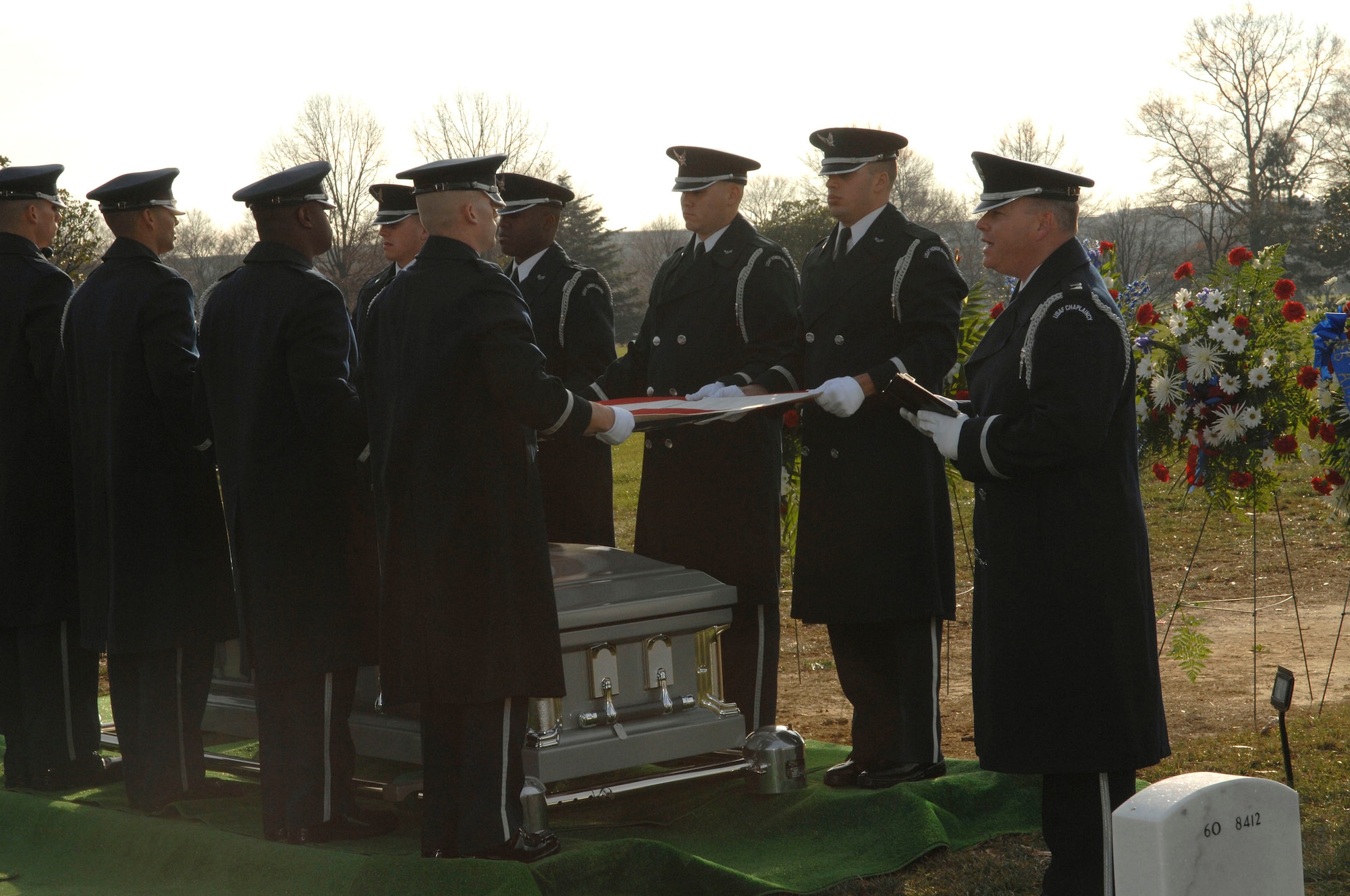 Chaplain (Capt.) Kenneth Fisher delivers a eulogy for Capt. Kermit Evans during his funeral as the Air Force Honor Guard prepares to fold the American flag Dec. 12 at Arlington National Cemetery. More than 200 friends and relatives gathered to pay their respects to Captain Evans, a member of the 27th Civil Engineering Squadron Explosives Ordnance Disposal Flight at Cannon Air Force Base, New Mexico. He was deployed to Iraq when the helicopter he was a passenger in made an emergency landing and crashed. (U.S. Air Force photo/Tech. Sgt. Cohen Young) 