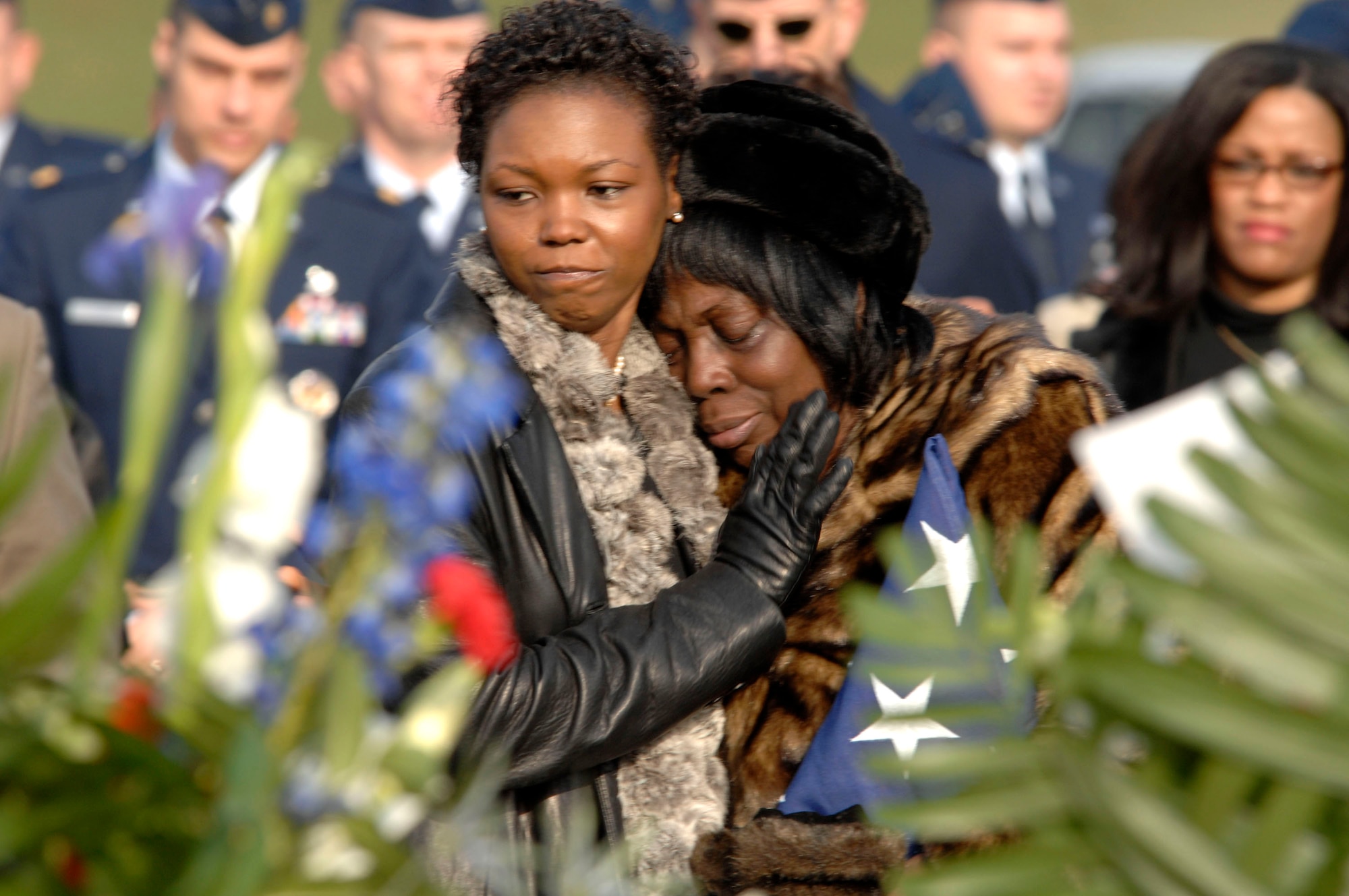 Margaret Evans (right) is comforted by a family member at the conclusion of the funeral for her son, Capt. Kermit Evans, Dec. 12 at Arlington National Cemetery. More than 200 friends and relatives gathered to pay their respects to Captain Evans. Captain Evans was a member of the 27th Civil Engineering Squadron Explosives Ordnance Disposal Flight at Cannon Air Force Base, N.M. He was deployed to Iraq when the helicopter he was a passenger in made an emergency landing and crashed. He was one of the four out of 16 who were killed as a result of the crash. He is srvived by his wife, Perneatha, and Kermit Jr., their 13-month-old son. (U.S. Air Force photo/Tech. Sgt. Cohen Young) 