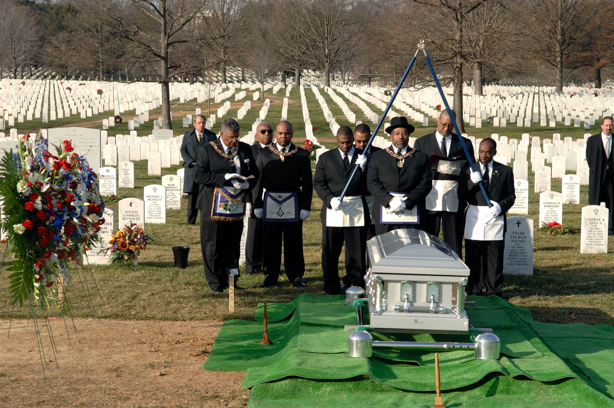 District Deputy Grand Master of the 31st Masonic District Clifton Johnson Sr. leads his lodge brothers in prayer beside the casket of Capt. Kermit Evans during the Masonic burial portion of his funeral Dec. 12 at Arlington National Cemetery. Captain Evans had been a Mason for more than a year. More than 200 friends and relatives gathered to pay their respects to Captain Evans, a member of the 27th Civil Engineering Squadron Explosives Ordnance Disposal Flight at Cannon Air Force Base, N.M. He was deployed to Iraq when the helicopter he was a passenger in made an emergency landing and crashed. He was one of the four out of 16 who were killed as a result of the crash. He is survived by his wife, Perneatha, and Kermit Jr., their 13-month-old son.(U.S. Air Force photo/Tech. Sgt. Cohen Young) 