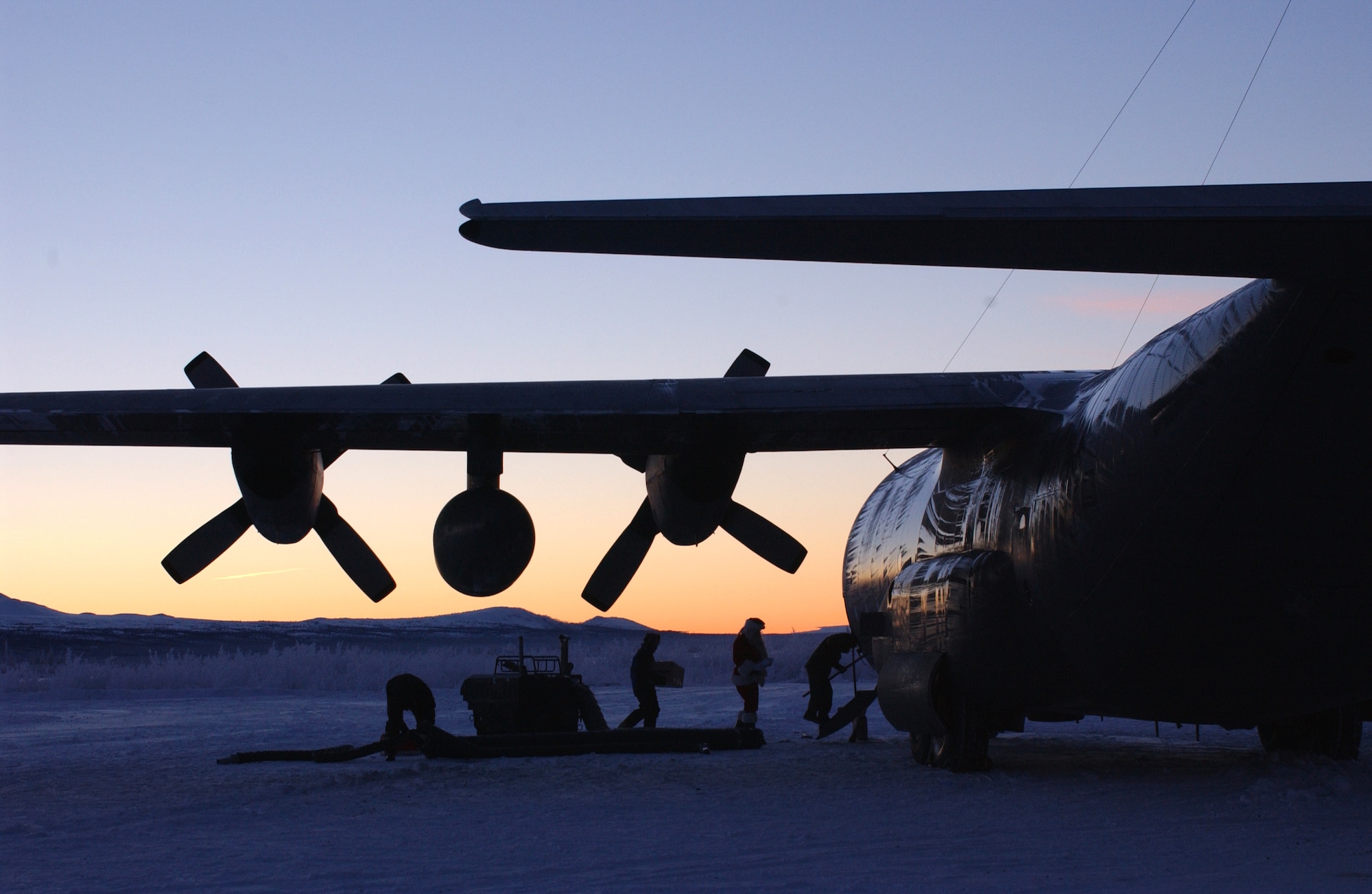 Santa and his elves board the C-130 Hercules after making a stop in Arctic Village, Alaska. The 517th Airlift Squadron from Elmendorf Air Force Base, Alaska has dropped off more than $8,500 worth of toys and food for the people of the village.  Santa made his 40th annual trip to Arctic Village (north of Fort Yukon, Alaska) on Dec 11.  Due to a change in aircraft at Elmendorf, this will be the last trip that the 517th Airlift Squadron will make to Arctic Village. The Alaska Air National Guard will add Arctic Village to its short list of destinations during Operation Santa. (U.S. Air Force photo/Staff Sgt. Rhiannon Willard)