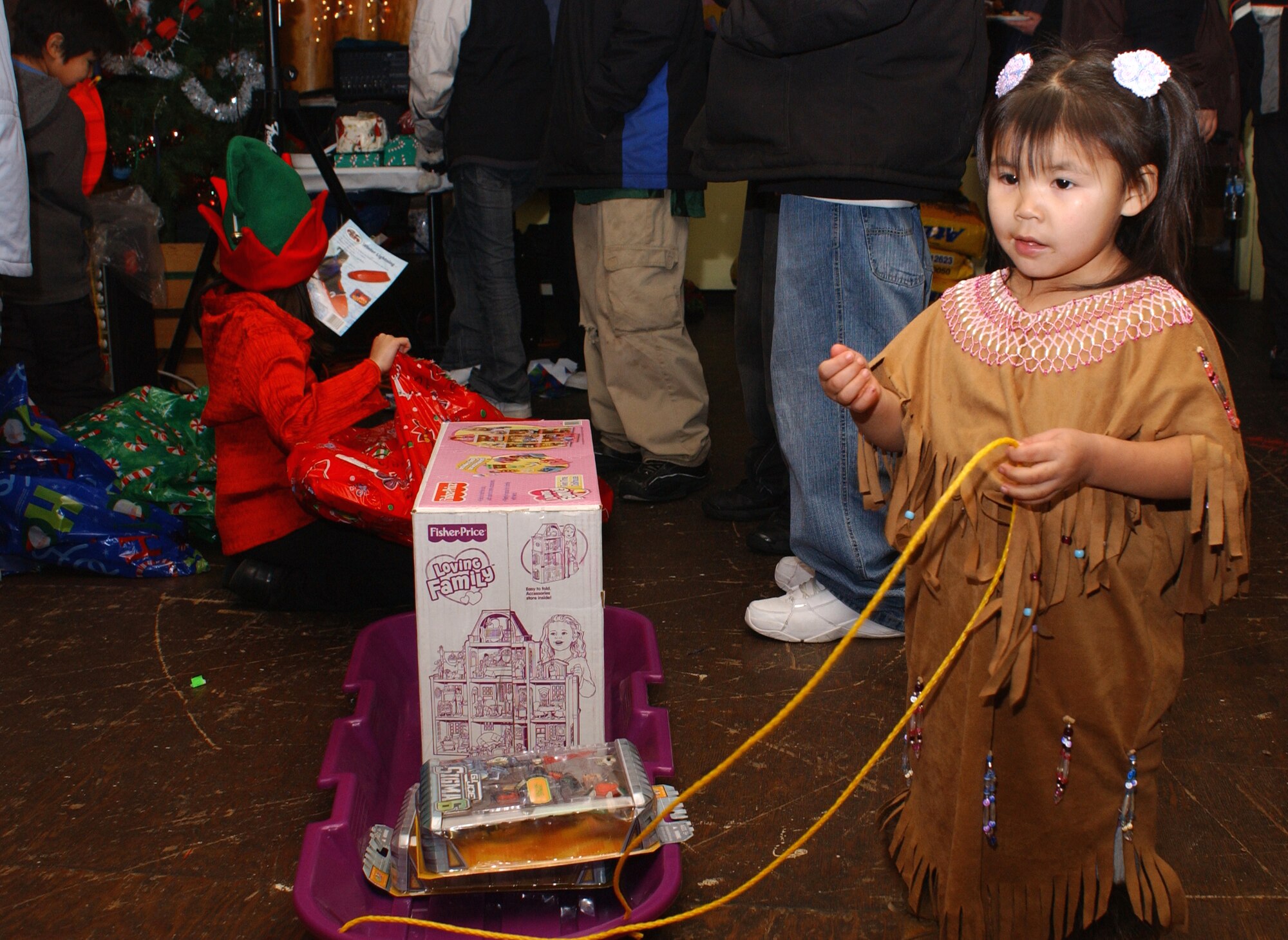 Three-year-old Kayla Nikolai carries her toys off in her new sled after visiting with Santa on Dec. 11. Santa made his 40th annual trip to Arctic Village (north of Fort Yukon, Alaska) with the help of the 517th Airlift Squadron's C-130 Hercules from Elmendorf, Alaska. Due to a change in aircraft at Elmendorf, this will be the last trip that the 517th Airlift Squadron makes to Arctic Village. The Alaska Air National Guard will add Arctic Village to its list of destinations during Operation Santa. (U.S. Air Force photo/Staff Sgt. Rhiannon Willard)
