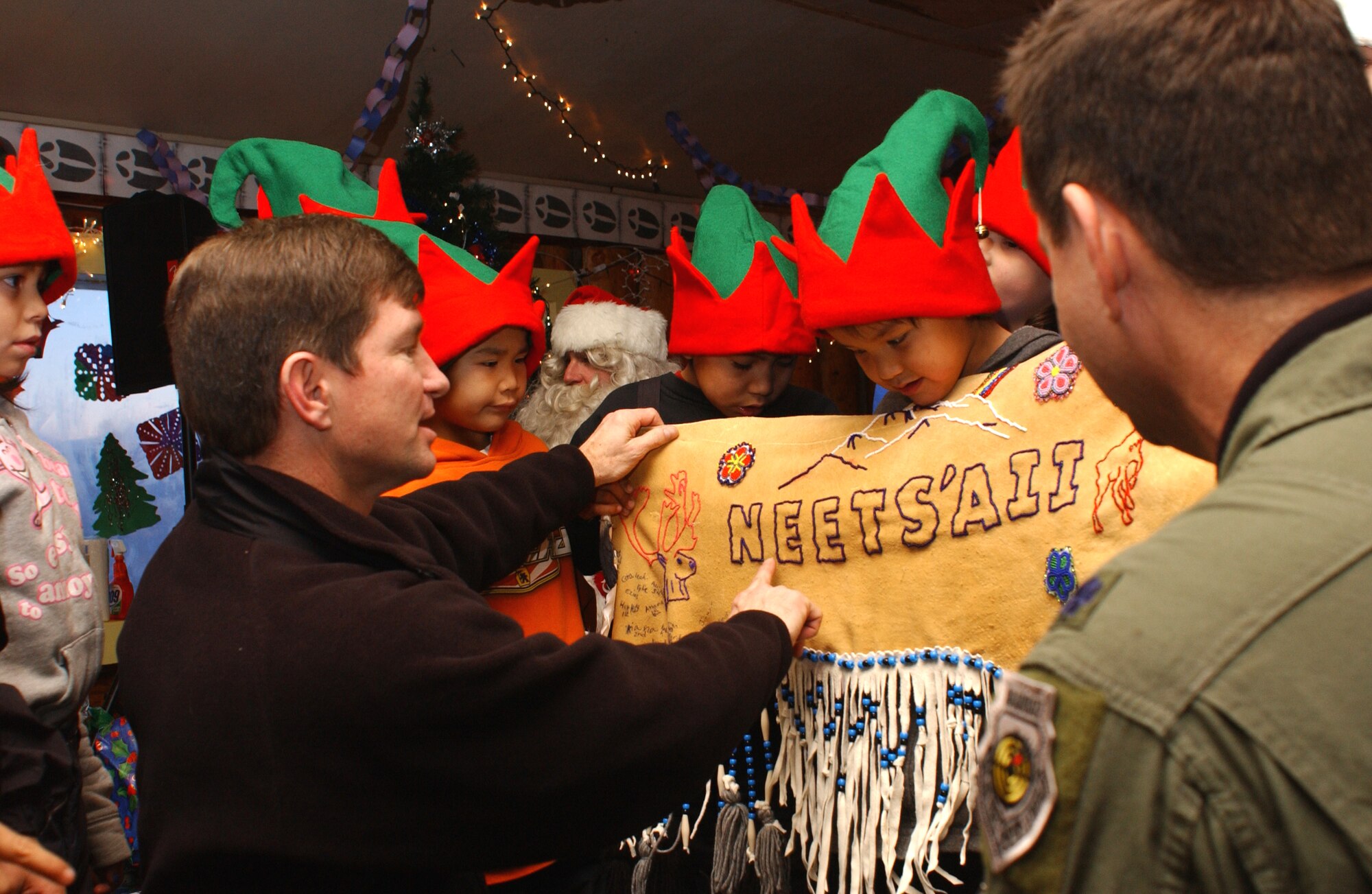 The 3rd Wing  vice commander Colonel Scotty Lewis, accepts a gift from the people of Arctic Village, Alaska. The gift, saying "Merry Christmas" in their native language, is a symbol of thanks to the 517th Airlift Squadron for 40 years worth of trips that the 517th AS from Elmendorf, Alaska has made to Arctic Village. They brought food, toys and Santa there each holiday season. Due to a change in aircraft at Elmendorf, this Dec. 11 trip will be the last that the 517th Airlift Squadron will make to Arctic Village. The Alaska Air National Guard will add Arctic Village to its list of destinations during Operation Santa. (U.S. Air Force photo/Staff Sgt. Rhiannon Willard)
