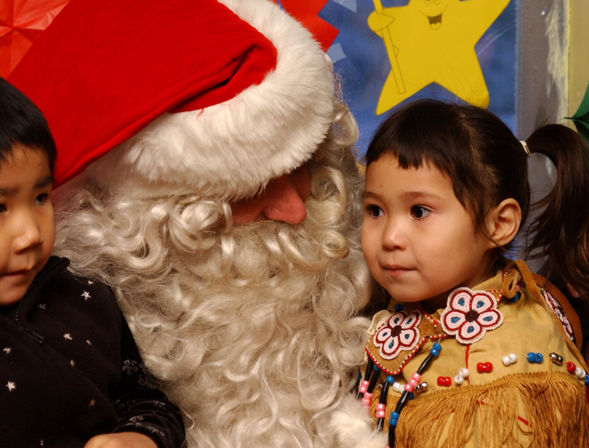 Santa holds 3-year-old Alyssa Gimmiel after arriving at the Arctic Village Community Center in Alaska.  Santa made his 40th annual trip to Arctic Village (north of Fort Yukon, Alaska) on December 11. The Alaska Air National Guard will add Arctic Village to its short list of destinations during Operation Santa. (U.S. Air Force photo by Staff Sgt. Rhiannon Willard)