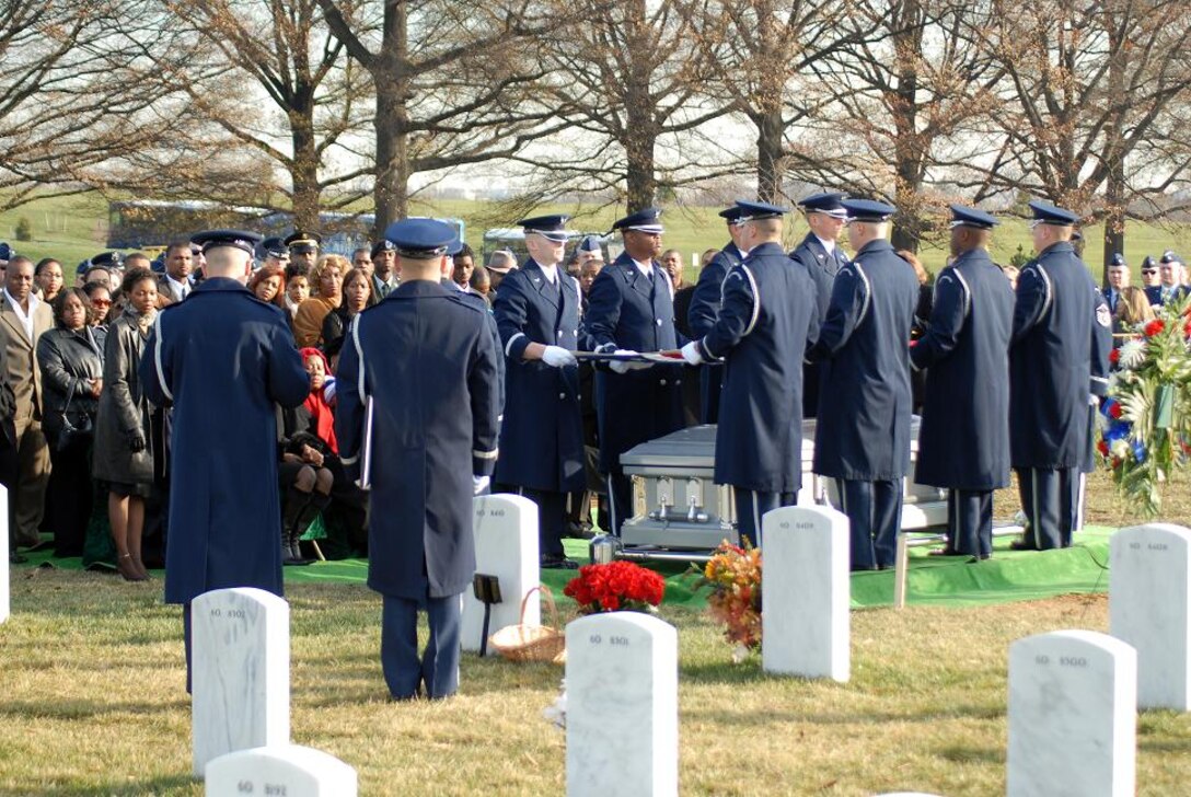 The body bearers fold the American flag while the chaplain performs his part of the ceremony. Friends and family attended to show their final respects for Capt. Kermit Evans who was killed Dec. 3 in Iraq. Captain Evans was killed in an emergency helicopter landing near the shore of Lake Qadisiyah in Al Anbar Province, Iraq. Captain Evans was one of 16 people aboard the Marine CH-46 helicopter and one of four servicemembers killed as a result of the landing. He is survived by his wife and 13-month-old son, Kermit Jr. Captain Evans was the commander of the 27th Civil Engineer Squadron Explosives Ordnance Disposal Flight at Cannon Air Force Base, N.M. (U.S. Air Force photo/Staff Sgt. Madelyn Waychoff)