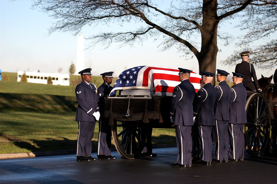 Air Force Honor Guardsmen transfer the casket carrying Maj. Troy Gilbert from the caisson to the grave site during a full honors funeral Dec. 11 at Arlington National Cemetery.  Major Gilbert was the pilot of an Air Force F-16 Fighting Falcon engaged in support of coalition ground combat operations that crashed approximately 20 miles northwest of Baghdad Nov. 27. (U.S. Air Force photo/Maj. Francisco G. Hamm)