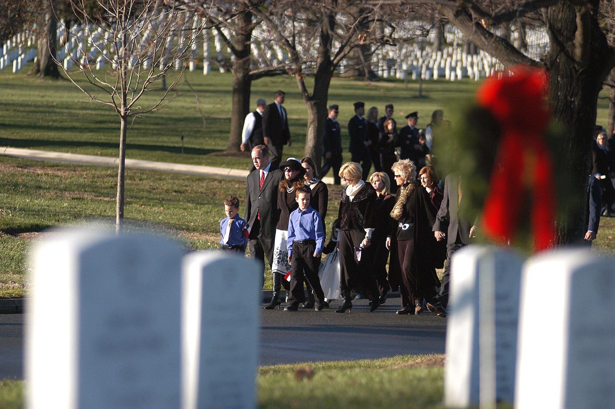 Family and friends of Maj. Troy Gilbert walk behind the caisson during the full honors funeral Dec. 11 at Arlington National Cemetery. Major Gilbert was the pilot of an Air Force F-16 Fighting Falcon engaged in support of coalition ground combat operations that crashed approximately 20 miles northwest of Baghdad Nov. 27. Major Gilbert was assigned to the 309th Fighter Squadron, Luke Air Force Base, Ariz., and was deployed to the 332nd Expeditionary Wing, Balad Air Base, Iraq. (U.S. Air Force photo/Maj. Francisco G. Hamm)
                                