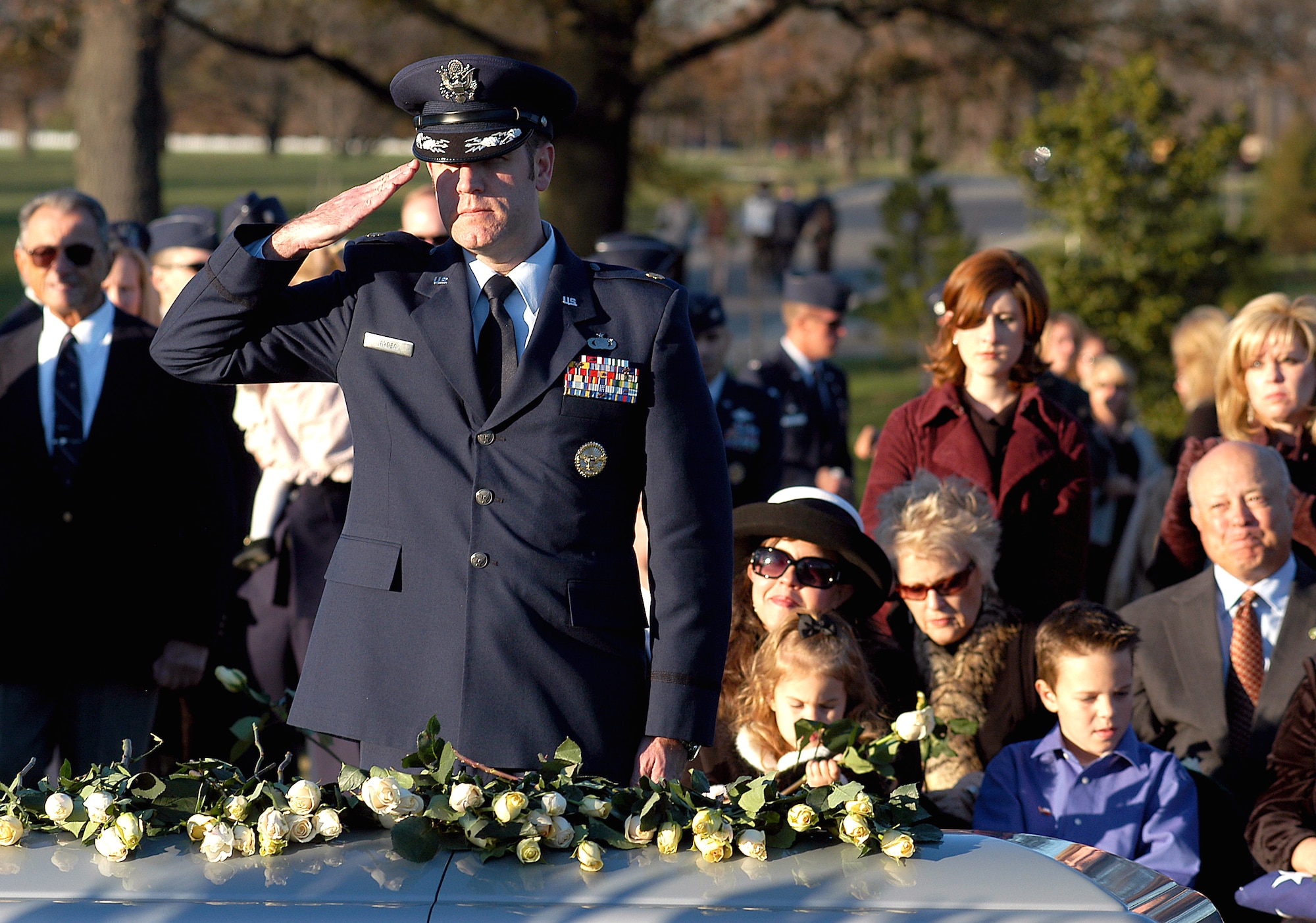 Maj. Patrick Ryder gives his friend, Maj. Troy Gilbert, a final salute while Ginger Gilbert, looks on Dec. 11 at Arlington National Cemetery. Major Gilbert was laid to rest here during a full honors funeral. A pilot of an Air Force F-16 Fighting Falcon, he engaged in support of coalition ground combat operations that crashed approximately 20 miles northwest of Baghdad Nov. 27. Major Gilbert was assigned to the 309th Fighter Squadron, Luke Air Force Base, Ariz., and was deployed to the 332nd Expeditionary Wing, Balad Air Base, Iraq. Major Ryder is from the Office of Assistant Secretary of Defense for Public Affairs. (U.S. Air Force photo/Maj. Francisco G. Hamm)
                                
                      