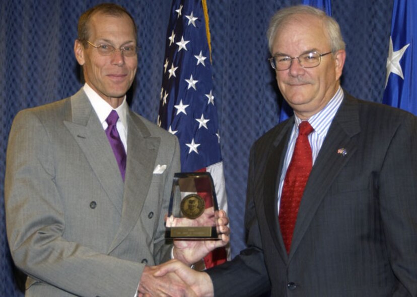 Dr. John Caldwell accepts the 2005 Harold Brown Award from Secretary of the Air Force Michael Wynne. (Air Force photo)