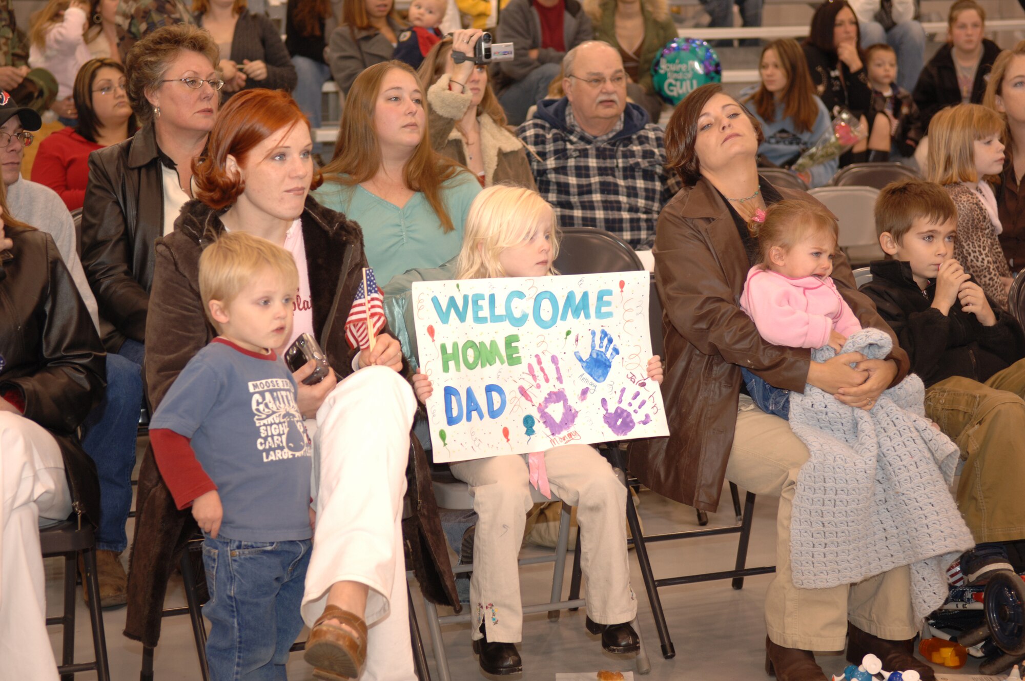 Families wait patiently for the arrival of their loved ones during Operation Homecoming in Commando Hangar Dec. 8. Operation Homecoming is a ceremony dedicated to supporting the men and women that are returning from deployment  overseas. (U.S. Air Force photo by Senior Airman Ali E. Flisek)