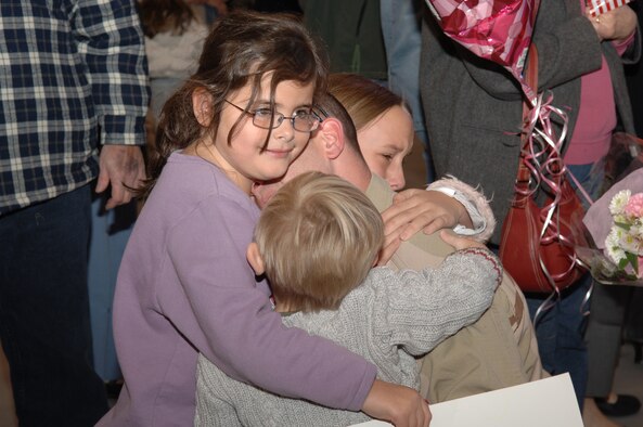 Families hug thier loved ones returning home from deployments during Operation Homecoming in Commando Hangar Dec. 8. Operation Homecoming is a ceremony dedicated to supporting the men and women that are returning from deployment  overseas. (U.S. Air Force photo by Senior Airman Ali E. Flisek)
