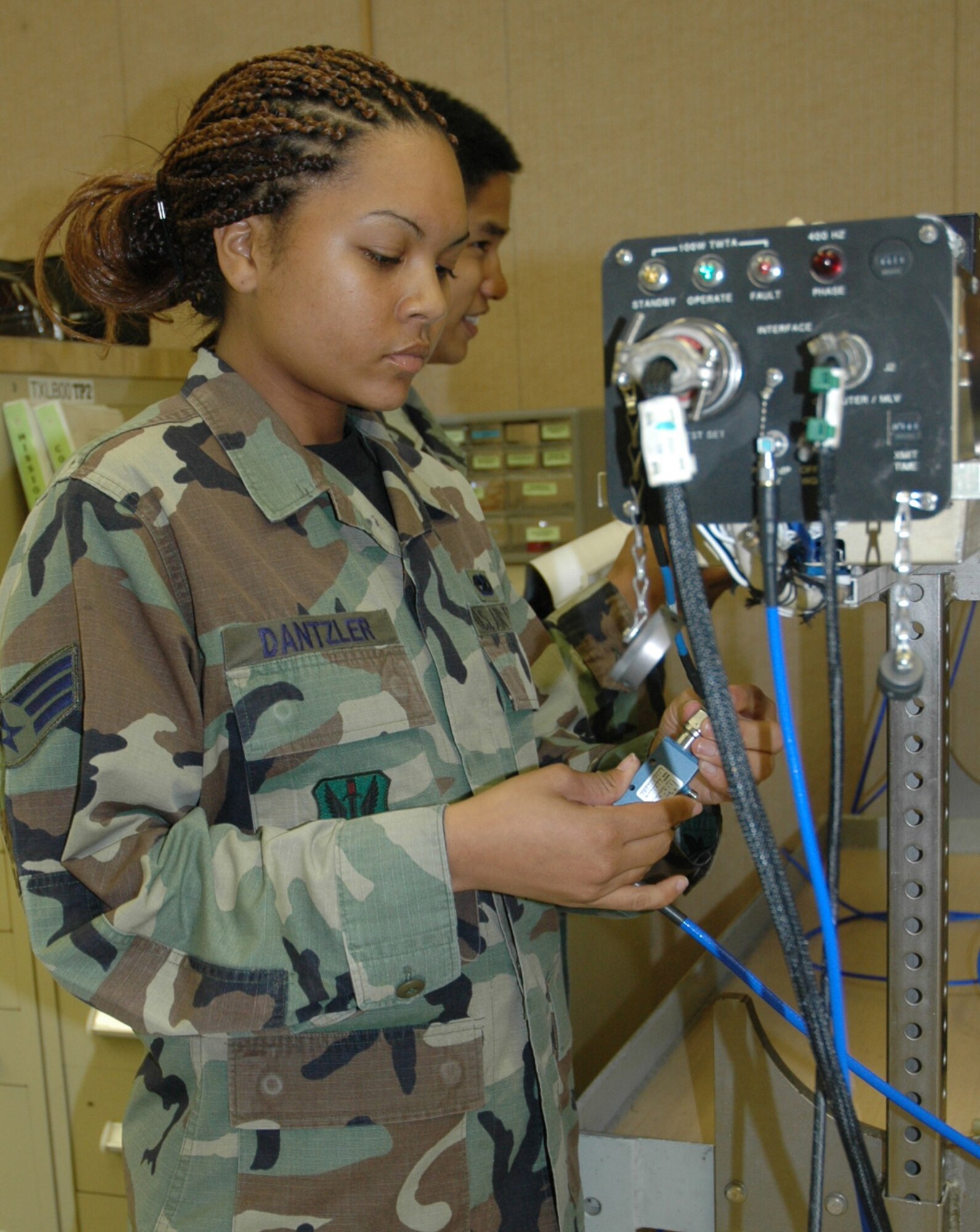 TYNDALL AIR FORCE BASE, Fla. --  Senior Airman Jennifer Dantzler, 28th Test Squadron/Detachment 2 electronic warfare technician, hooks up wires on to the electronic warfare defense pod used on Air Force fighter jets. The squadron, one of Tyndall’s tenant units, won the Air Force Association’s 2006 Theodore Von Karman Award for outstanding contributions to national defense in the field of science and engineering related to aerospace activities. Electronic warfare systems, like the one pictured here, and its associated capabilities are part of more than 400 test missions in support of 17 programs accomplished in 2006 across the Combat Air Forces. Specifically, the pod in the picture is an essential tools for testing and training on F-15 and F-16 aircraft radar and avionics suites. (U.S. Air Force photo by Chrissy Cuttita)