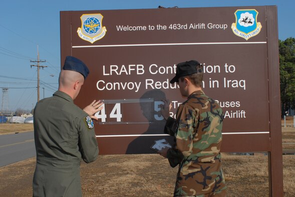 Senior Airman Stephen Bryant (left), a 61st Airlift Squadron loadmaster, and Airman 1st Class Denton Lester, a 463rd Aircraft Maintenance Squadron crew chief, update the numbers on the LRAFB Contribution to Convoy Reduction in Iraq sign Dec. 12 to 4,455 trucks and buses reduced by airlift. The sign outiside the 463rd Airlift Group headquarters building tracks the number of trucks and buses by airlifting people and equipment instead of dangerous convoy missions.
Photo by Airman 1st Class Christine Clark