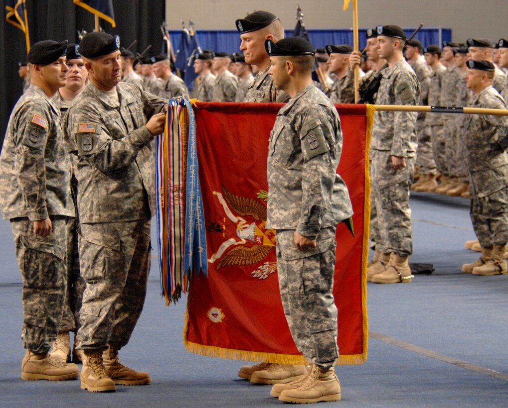 U.S. Army Col. Michael Shields attaches a new battle streamer to the guidon during the 172nd Stryker Brigade Combat Team's redeployment ceremony at Fort Wainwright, Alaska, Dec. 12.