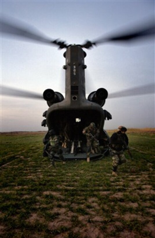 U.S. Army soldiers with 2nd Battalion, 35th Infantry Regiment, 25th Infantry Division and Iraqi army soldiers from Emergency Service Unit dismount from a CH-47 Chinook helicopter to conduct a cordon and search operation in villages in the Kirkuk province of Iraq on Dec. 7, 2006.  