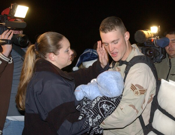 Senior Airman Jason Geldrich, 99th Security Forces Squadron, returns home to Nellis Air Force Base, Nev., Dec. 12. Airman Geldrich holds his son, Jason Jr., for the first time while his wife, Becca, reunites her family. (U.S. Air Force photo/Staff Sgt. Jeremy Smith)                                                    