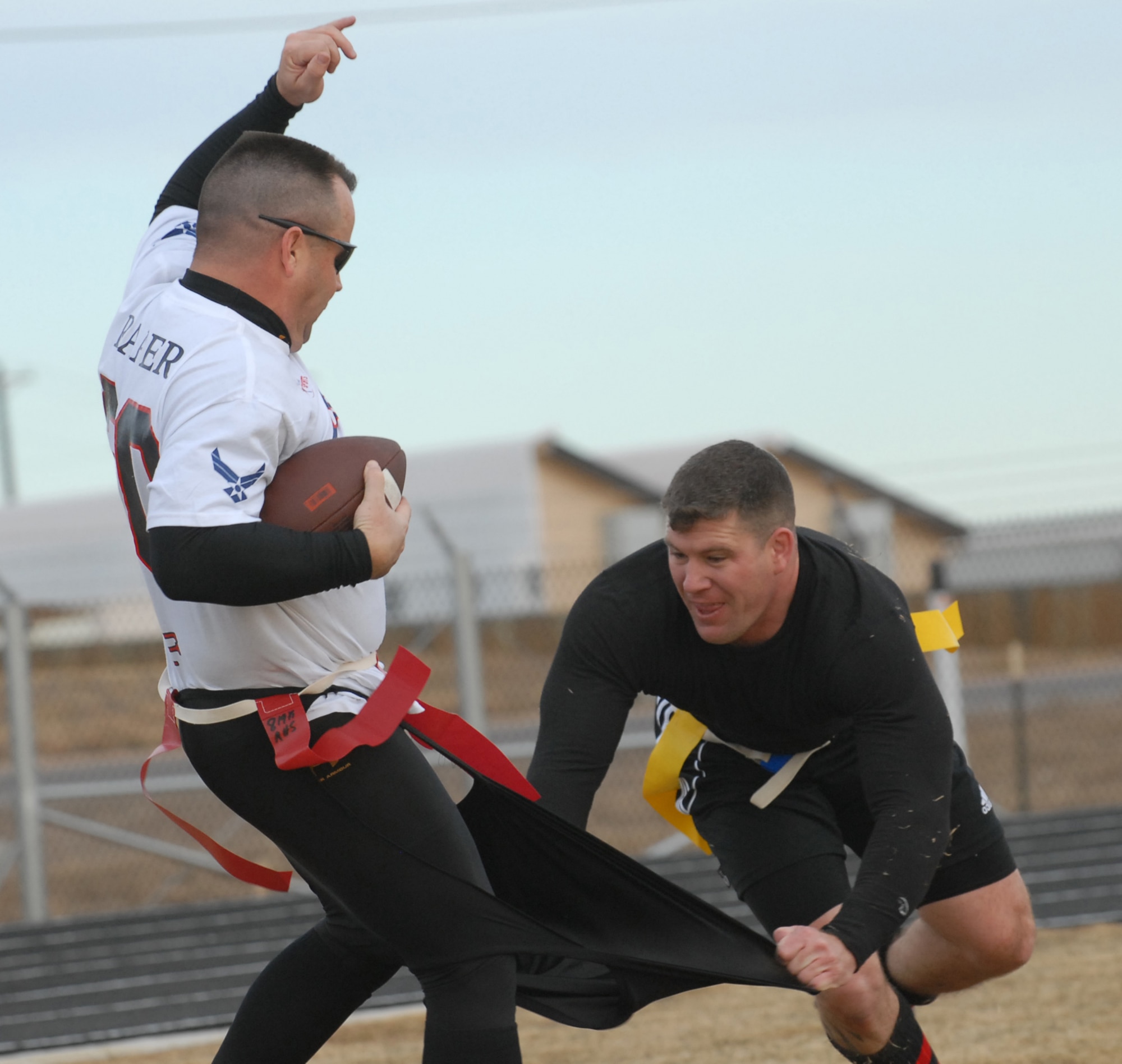 Eagles/Commanders team member Jeff Beckford rips Chiefs/Shirts Randall Raper's shorts off during a flag football game Dec. 14 that was put on to raise canned goods for Operation Warmheart and give base enlisted and officer leadership a chance for friendly competition. The Chiefs/Shirts shut the Eagles/Commanders out 31-0. (U.S. Air Force photo by Airman 1st Class Alex Gochnour)