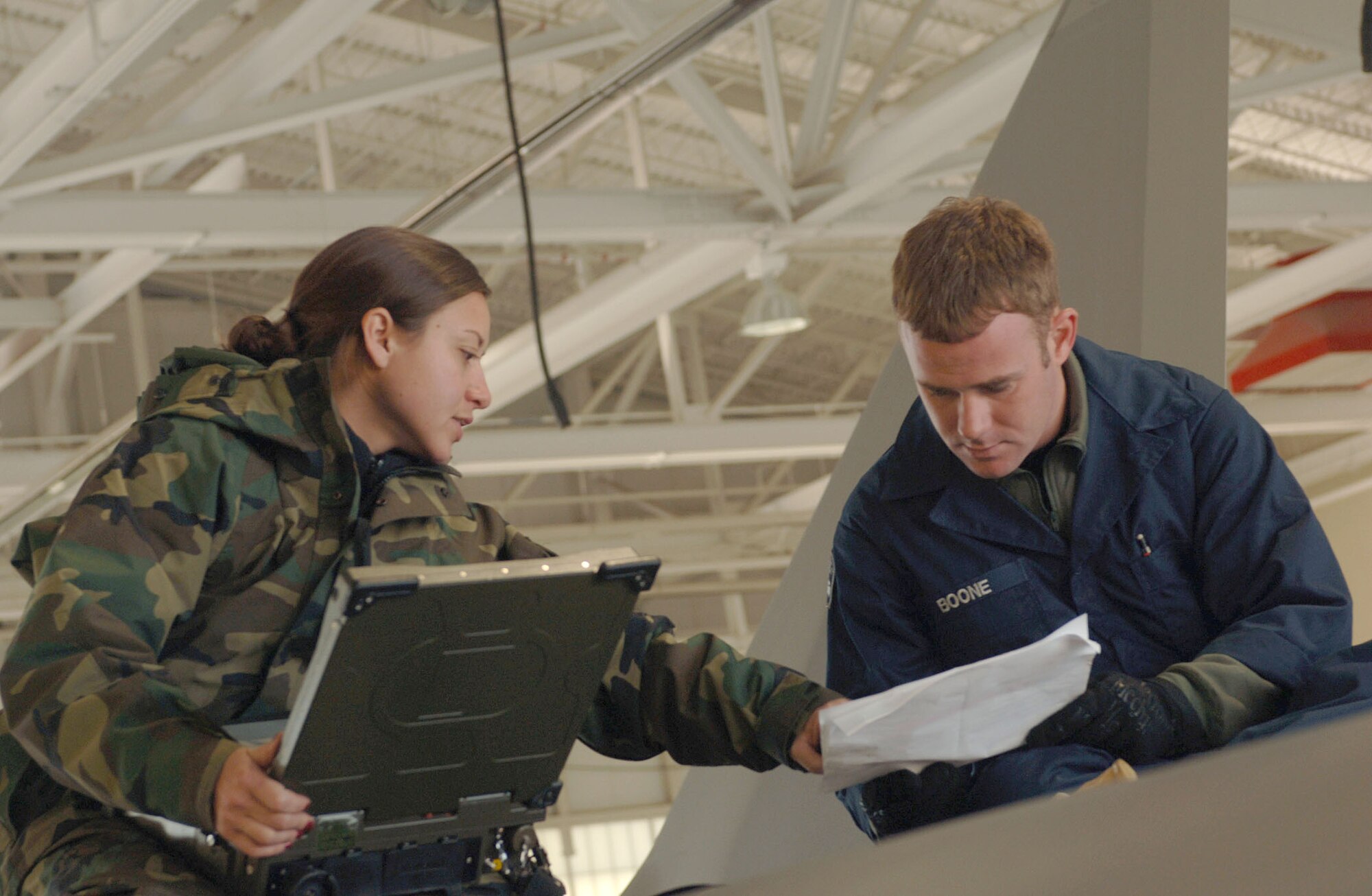 Staff Sgt's Toni Brooks (left) and Bradford Boone (right), both 192nd Virginia Air National Guard aircraft maintainers attached to the 94th Fighter Squadron at Langley Air Force Base in Virginia, troubleshoot the avionics system on a F-22A Raptor using the Portable Maintaince Adapter (PMA) on Dec. 6, 2006.For well over a year, aircraft maintainers and pilots from the 192nd Virginia Air National Guard Unit based out of Richmond, Va. have slowly intergrated into the F-22A Raptor program at Langley AFB. (USAF Photo By Staff Sgt Samuel Rogers)
 