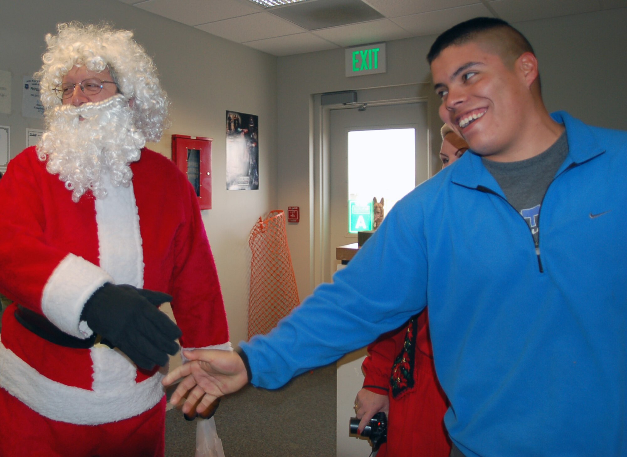 Santa, or Deacon Richard Borda from the 460th Space Wing Chapel, delivers cookies to Staff Sgt Martin Campos, from the 460th Security Forces Squadron K-9 unit, and his colleagues Dec. 14 as part of the chapel's annual Cookie Caper drive. The chapel collected close to 10,000 cookies to deliver to every Buckley unit.