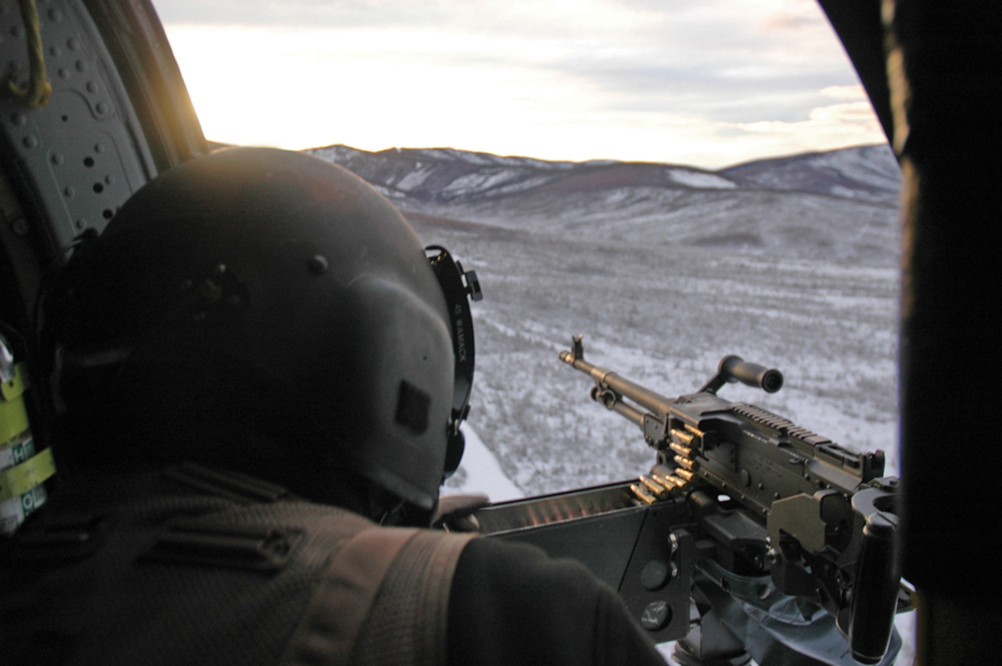 EIELSON AIR FORCE BASE, Alaska--Senior Airman Eli Wamack, Det. 1, 210th  Rescue Squadron helicopter flight engineer, scans the terrain for targets from a Sikorsky HH-60G Pavehawk during a training mission Dec. 7 on the Pacific Alaska Range Complex. (U.S. Air Force photo by Airman Nora Anton)