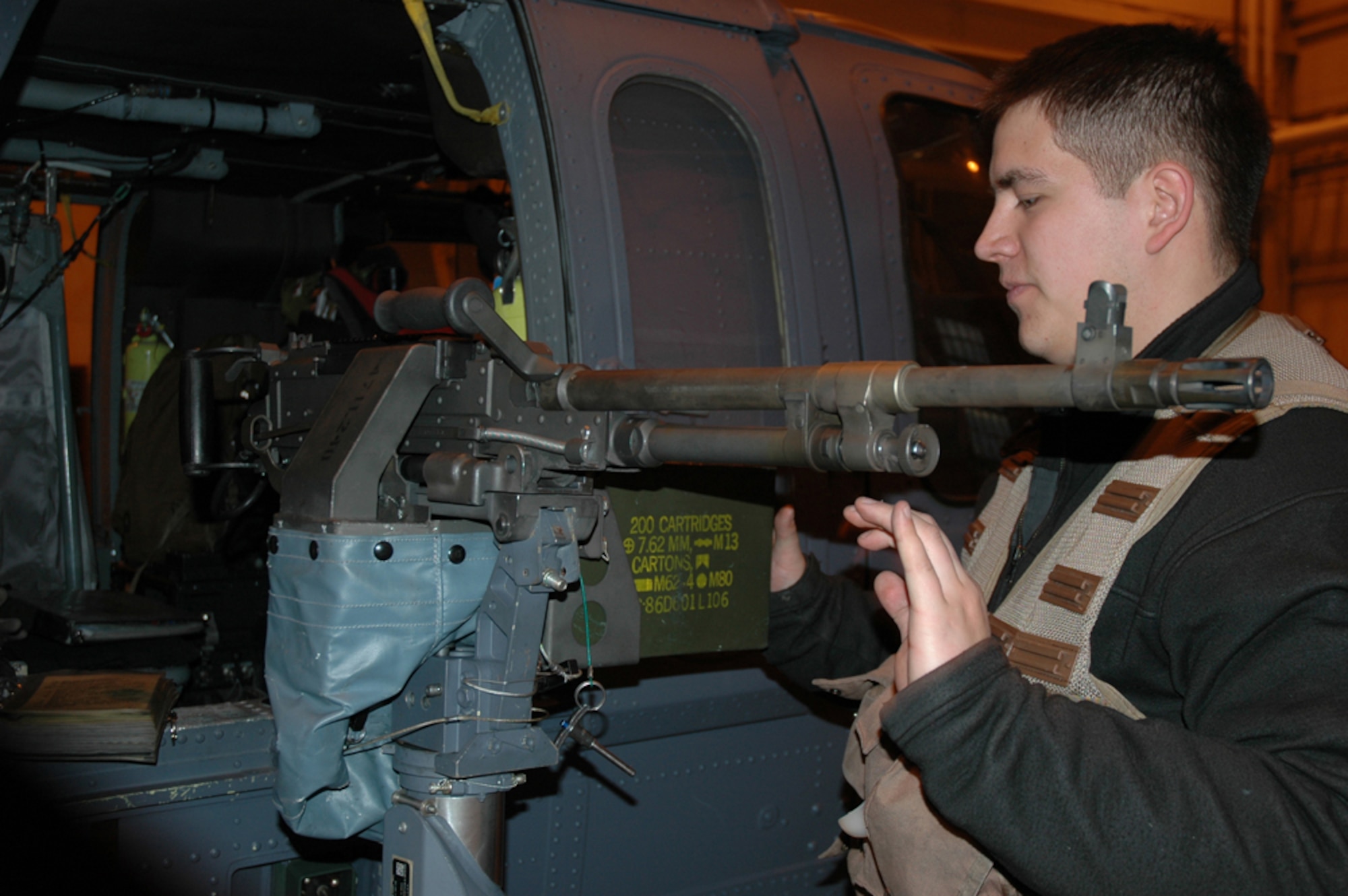EIELSON AIR FORCE BASE, Alaska--Senior Airman Eli Wamack, Det. 1, 210th helicopter flight engineer,  inspects a M240 machine gun before leaving on a two-hour training mission Dec. 7 in the Pacific Alaska Range Complex. (U.S. Air Force photo by Airman Nora Anton)