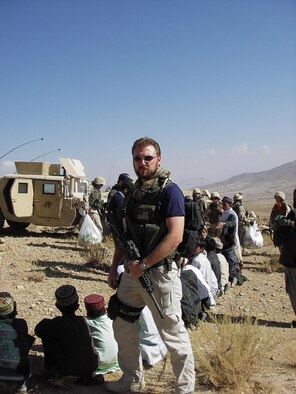 AFGHANISTAN -- Air Force Office of Special Investigations Special Agent Geoffrey Keller, Expeditionary Detachment 2405, stands guard as U.S. Forces distribute aid to local children. Agent Keller, who is stationed at Hanscom, will be presented the Bronze Star Medal Wednesday. (Courtesy photo)