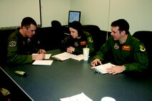MINOT AIR FORCE BASE, N.D. – (From left) Capts. Josh Holmes, Telisha McClure and Jeremy Holmes, all from the 23rd Bomb Squadron, discuss mission planning Monday afternoon in preparation for a training sortie Tuesday. This sortie was unique because it featured four family members participating in the same mission. (U.S.  Air Force photo by Airman Wesley Wright)