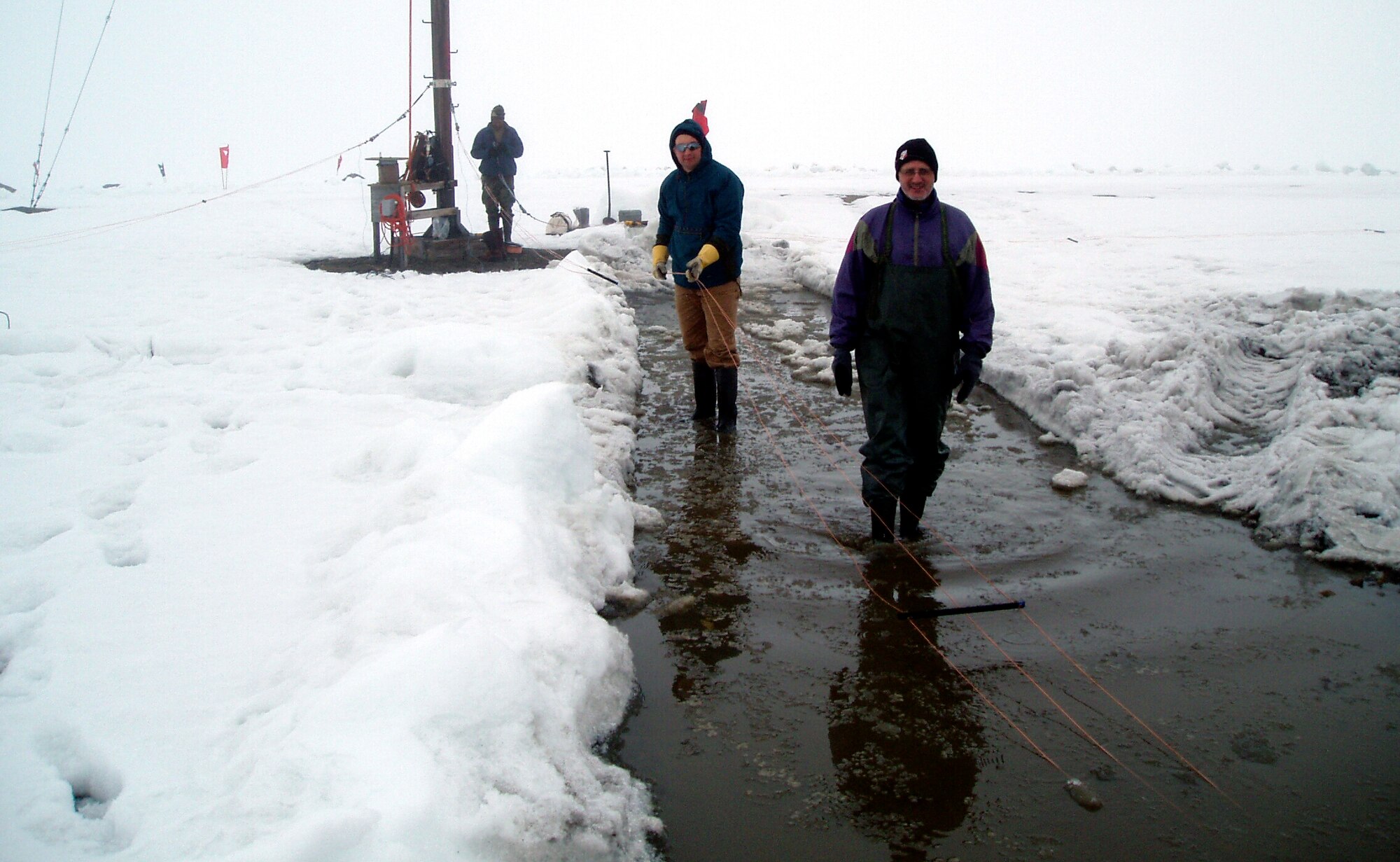 2nd Lt. Isseyas Mengistu (background), 1st Lt. Robert Esposito (middle) and Jake Quinn, researchers serving with Air Force Research Laboratory’s Space Vehicles Directorate, lay out the ionosonde antenna elements on the frozen tundra of Greenland prior to hoisting them up an 82-foot pole.  (Air Force photo)