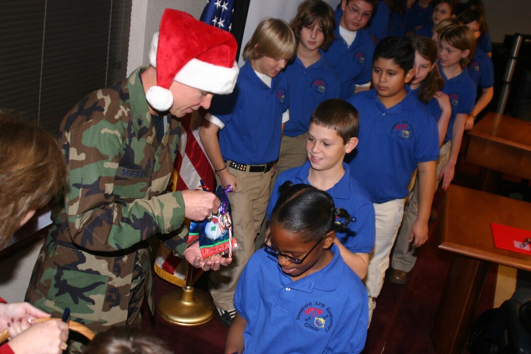 Brig. Gen. Richard Devereaux, 82nd Training Wing commander, passes out goody bags Dec. 12 following a morning performance by the Sheppard Elementary Choir. (U.S. Air Force photo/John Ingle)