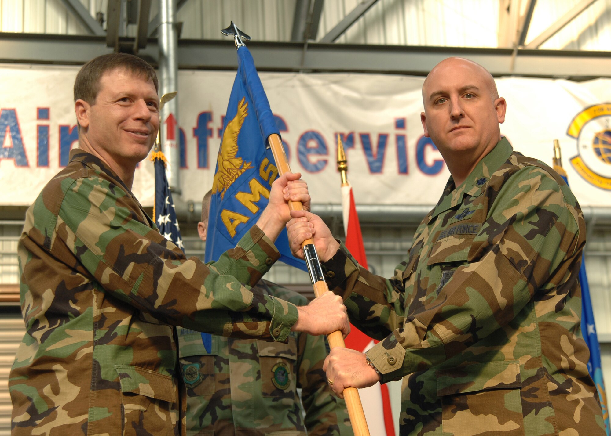 Col. Ross A. Victor, left, 721st Air Mobility Operations Group, passes the command of the 728th Air Mobility Squadron to Lt. Col. Joseph F. Angel during a change of command ceremony, Dec. 13. (U.S. Air Force photo by Airman 1st Class Kelly L. LeGuillon)