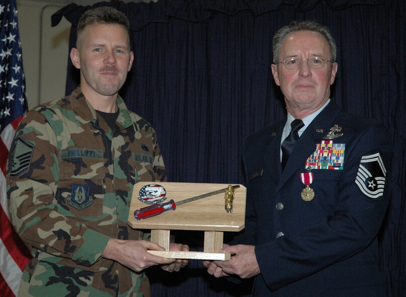 YOUNGSTOWN AIR RESERVE STATION, Ohio -- Air Force Reserve Senior Master Sgt. William A. Rooks Jr., a flight chief with the 910th Aircraft Maintenance Squadron, retired during a Dec. 2, 2006 ceremony here after a 35-year career with the Air Force and Air Force Reserve.  After spending many years of his career supporting the aerial spray mission, Sergeant Rooks was a pioneer in the development and operation of the Modular Aerial Spray Systems (MASS) used on board specially modified aerial spray C-130s today.  Here, Sergeant Rooks receives the 910th Maintenance Squadron's coveted Silver Screwdriver Award from Master Sgt. Sam J. Phillippi, a 910th crew chief.  U.S. Air Force photo/Master Sgt. Bryan Ripple.
