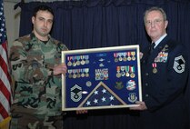 YOUNGSTOWN AIR RESERVE STATION, Ohio -- Air Force Reserve Senior Master Sgt. William A. Rooks Jr., 910th Aircraft Maintenance Squadron Flight Chief, receives a retirement shadow box capturing the memories of years of service with the U.S. Air Force and Air Force Reserve from 1st Lt. Rocco A. Favorite, 910th Aircraft Maintence Squadron officer during Sergeant Rooks' retirement ceremony here Dec. 2.  Prior to becoming a flight chief with the maintenance squadron, Sergeant Rooks was the chief of Aerial Spray Maintenance for many years and was instrumental in the development and maintenance of the Modular Aerial Spray Systems used to conduct aerial spray missions today. The 910th Airlift Wing is home to the only full-time, fixed-wing aerial spray capability in the Department of Defense. U.S. Air Force photo/Master Sgt. Bryan Ripple.