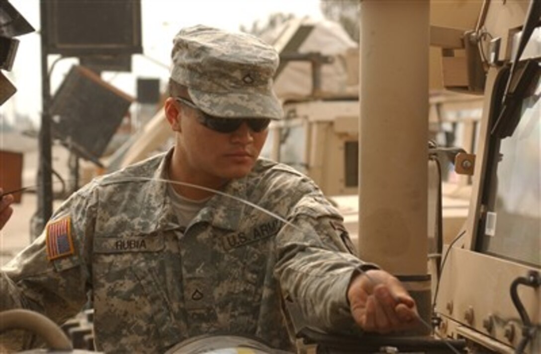 U.S. Army Pfc. Edward Rubia checks the steering fluid of his humvee during precombat checks prior to departing Forward Operating Base Iskandariyah, Iraq, to conduct a patrol on Dec. 6, 2006.  Rubia is assigned as a paratrooper to Charlie Company, 1st Battalion, 501st Parachute Infantry Regiment.  