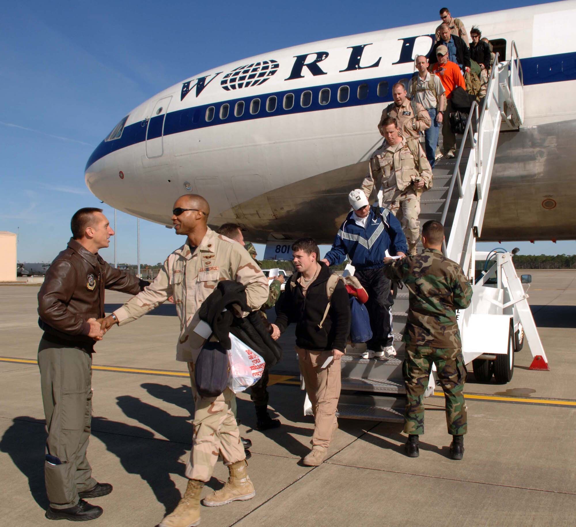 Chief Master Sgt. James Kradel, 1st Special Operations Wing acting command chief, greets the Airmen returning from Southwest Asia as tehy deplane at Commando Hangar Dec. 8 during Operation Homecoming. (U.S. Air Force Photograph by Senior Airman Ali Flisek)