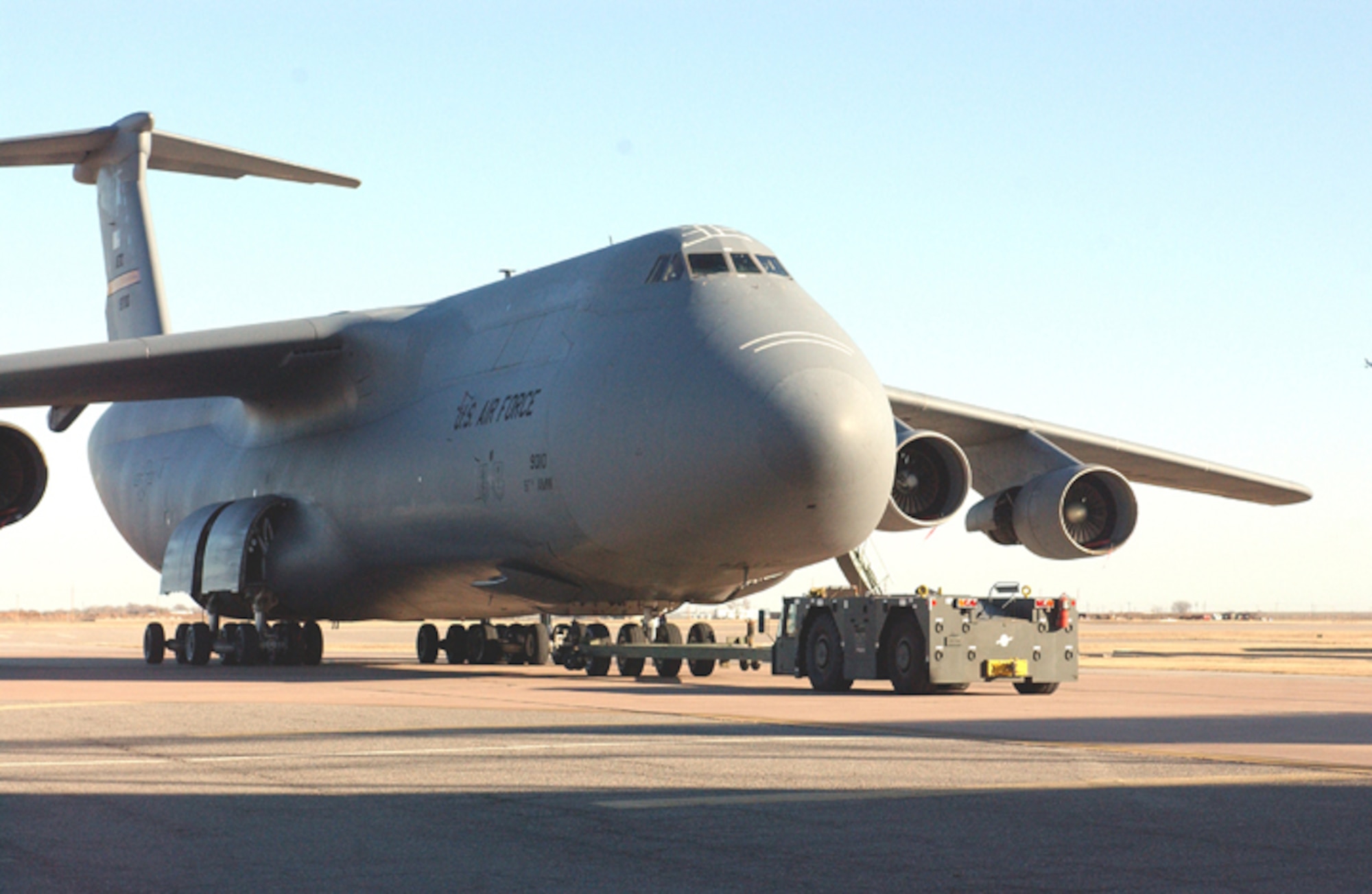 Though dwarfed by the Air Force’s largest cargo aircraft,a U-30 tow vehicle pushed an Altus C-5 Galaxy out of Hangar 435 after members of the 97th Maintenance Directorate replaced the landing gear on the aircraft Dec. 12.  A C-5 without fuel  weighs 376,000 pounds, however, the U-30 is designed to tow aircraft weighing up to 800,000 pounds.  (U.S. Air Force photo/Staff Sgt. Monique Randolph) 