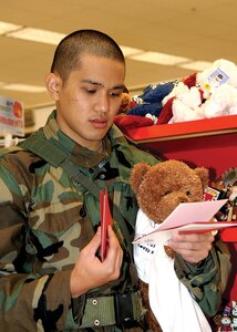 Trainee Ryan Kanasusuku, 324th Training Squadron, selects cards and gifts at the Main Exchange on Lackland Air Force Base during the Shop-A-Trainee program Dec. 9.