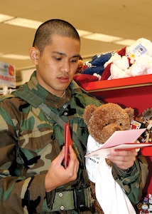 Trainee Ryan Kanasusuku, 324th Training Squadron, selects cards and gifts at the Main Exchange on Lackland Air Force Base during the Shop-A-Trainee program Dec. 9.