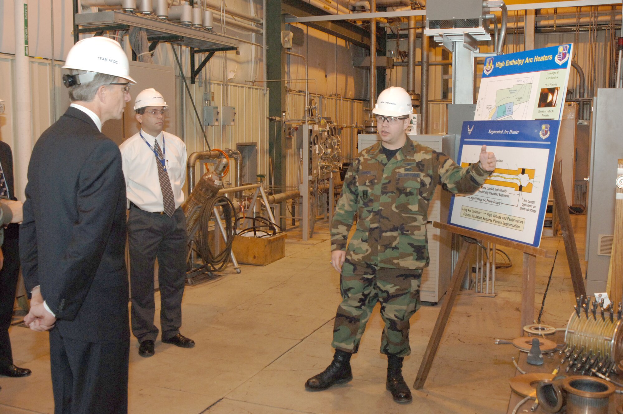 Second Lt. David Cancel, 718th Test Squadron project manager, briefs undersecretary of the Air Force Dr. Ronald Sega on the Arc Heaters at that facility. Looking on is Jeffrey Staines, Space and Missiles technology project manager. (Air Force photo by Rick Goodfriend)