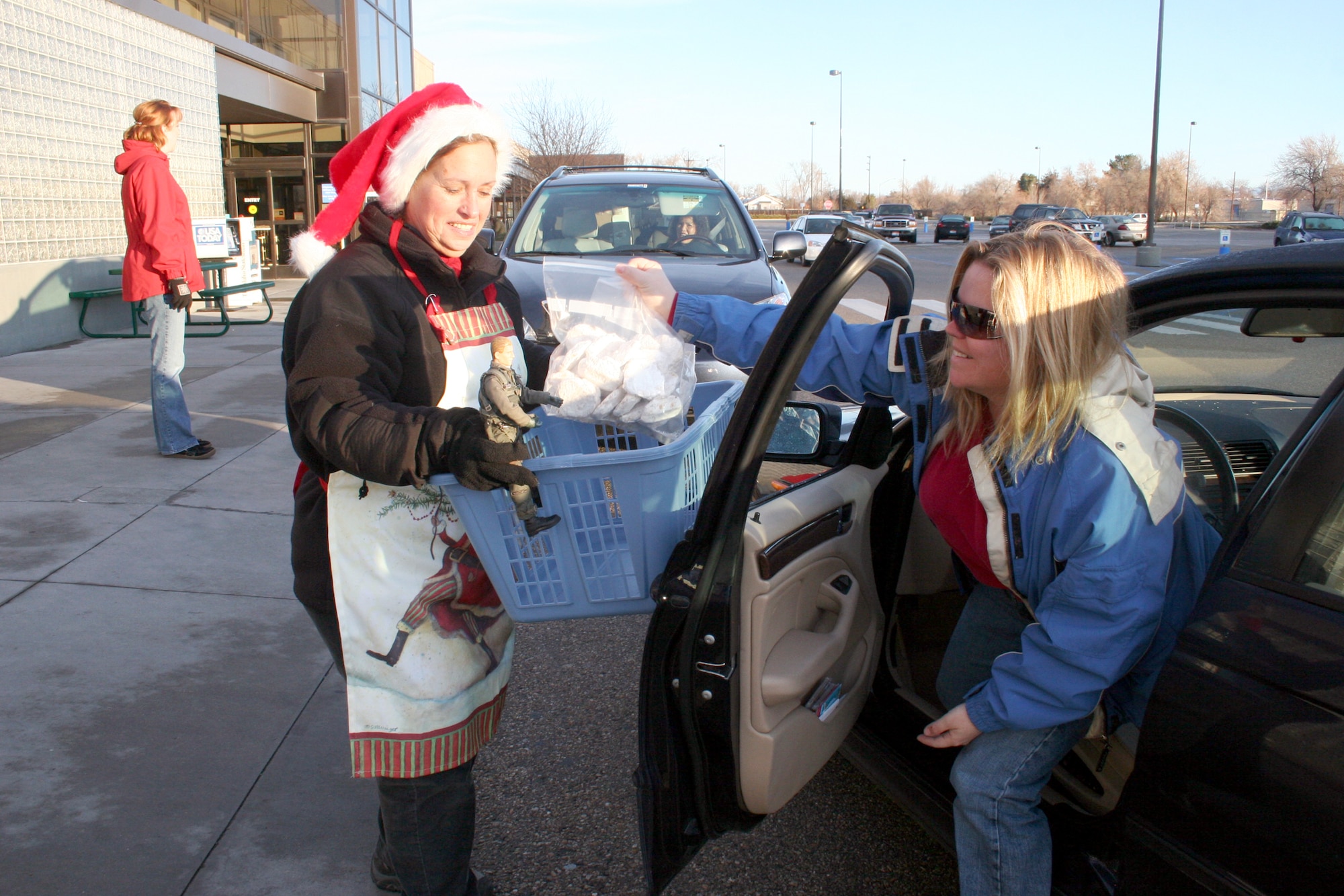 Viper helps Gwenn Liberti collect cookies Gunfighters donated to  the 366th Fighter Wing during the annual Airman Holiday Cookie Drive Monday at the commissary. Thanks to the generosity of the Gunfighters, the cookie drive project officers collected 1,000 dozen cookies to provide a “taste of home” for the Airmen stationed here and those currently deployed. (U.S. Air Force Photo/1st Lt. Erin Tindell)
